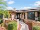 Inviting front entrance with brick accents, decorative plants, and glass-paneled double doors at 647 Saranac Dr, Winter Springs, FL 32708