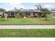 Charming brick home featuring manicured lawn, decorative trees and solar panels on the roof at 647 Saranac Dr, Winter Springs, FL 32708