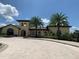 Elegant community center with palm trees and stone driveway at 7400 Soiree Way, Reunion, FL 34747