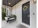 Front porch with hanging swing bed and black front door at 7400 Soiree Way, Reunion, FL 34747