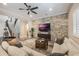 Open living room with sectional sofa, stone feature wall, and hardwood floors at 7400 Soiree Way, Reunion, FL 34747