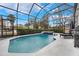 Enclosed pool and spa with seating and grilling area at 7400 Soiree Way, Reunion, FL 34747