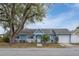 Light blue house with a white garage door and landscaping at 8465 Oak Bluff Dr, Orlando, FL 32827