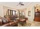 Elegant living room featuring a comfortable leather sofa and access to a backyard patio at 13412 Heswall Run, Orlando, FL 32832