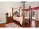 Luxurious main bedroom with a large four poster bed, hardwood floors and access to a patio at 13412 Heswall Run, Orlando, FL 32832
