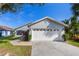 Gray house with white garage door and landscaping at 1511 Oak Hill Trl, Kissimmee, FL 34747