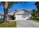 Gray house with white garage door, landscaping, and driveway at 1511 Oak Hill Trl, Kissimmee, FL 34747