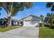 Gray house with white garage door and landscaping at 1511 Oak Hill Trl, Kissimmee, FL 34747