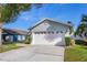 Gray house with white garage door and landscaping at 1511 Oak Hill Trl, Kissimmee, FL 34747
