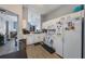 White kitchen with appliances, ample counter space, and wood-look floors at 1511 Oak Hill Trl, Kissimmee, FL 34747