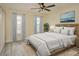 Bright bedroom with light gray bedding, wood flooring, and ceiling fan at 212 Meadow Blvd, Sanford, FL 32771