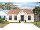 Tan house with brown roof, black door, and small front yard at 212 Meadow Blvd, Sanford, FL 32771