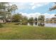 Scenic view of a lake with lush green grass and mature trees at 212 Meadow Blvd, Sanford, FL 32771