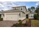 Charming gray home with a well-manicured lawn, lovely landscaping, and a spacious two car garage at 223 Cherokee Hill, Deland, FL 32724