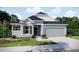 Charming single-Gathering home showcasing stone accents, a two-car garage, and a well-maintained lawn at 25122 Ensley Rd, Sorrento, FL 32776