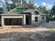New home under construction features a spacious garage and modern window design at 25122 Ensley Rd, Sorrento, FL 32776