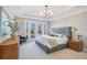 Main bedroom features a gray upholstered bed, and access to backyard at 2730 Meadow Sage Ct, Oviedo, FL 32765