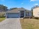 One-story home with blue exterior, paver driveway, and landscaping at 33931 Terragona Dr, Sorrento, FL 32776