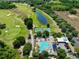 Aerial view of community amenities including pool, tennis courts, and golf course at 3439 Feathergrass Ct, Harmony, FL 34773