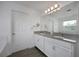 Bathroom with double vanity, large mirror, and grey countertop at 3439 Feathergrass Ct, Harmony, FL 34773
