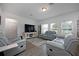 Spacious living room with gray sofas and large TV at 3439 Feathergrass Ct, Harmony, FL 34773