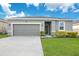 One-story house with gray siding, two-car garage, and landscaped lawn at 3482 Forster Ave, Leesburg, FL 34748