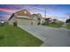 View of the home's exterior with a large driveway, well-maintained lawn and professional landscaping at 359 Briarbrook Ln, Haines City, FL 33844