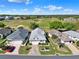 Panoramic aerial of single-story home in a golf community with lush lawns and mature trees under a blue sky at 5024 St Andrews Arc, Leesburg, FL 34748