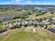 Aerial view of the neighborhood showcasing houses, landscaping, a golf course, and lakes at 5024 St Andrews Arc, Leesburg, FL 34748
