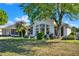 Backyard view showcasing a well-maintained lawn, patio area, and large windows to let in natural light at 5024 St Andrews Arc, Leesburg, FL 34748