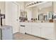 Bright bathroom featuring double sinks, ample cabinet space, and a large mirror for convenience at 5024 St Andrews Arc, Leesburg, FL 34748