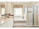 Well-appointed bathroom features a soaking tub and glass-enclosed shower for a relaxing experience at 5024 St Andrews Arc, Leesburg, FL 34748