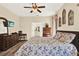 Inviting bedroom features a ceiling fan, wood floors, TV, and ensuite bathroom access for convenience at 5024 St Andrews Arc, Leesburg, FL 34748