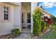 Inviting front entrance featuring a charming porch with decorative plants and a storm door at 5024 St Andrews Arc, Leesburg, FL 34748