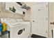 Bright laundry room featuring a white washer and dryer with storage cabinets above for convenience at 5024 St Andrews Arc, Leesburg, FL 34748