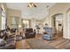 Bright living room featuring an open layout, hardwood floors, vaulted ceiling, and comfortable seating area at 5024 St Andrews Arc, Leesburg, FL 34748