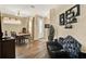 Open-concept living area showcasing a dining table set, a cozy leather sofa, and a charming entryway at 5024 St Andrews Arc, Leesburg, FL 34748