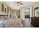 Spacious main bedroom with a TV, wood floors, and access to a sunlit living area and patio at 5024 St Andrews Arc, Leesburg, FL 34748