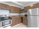 Galley kitchen with brown cabinets and stainless steel appliances at 514 S Crystal Lake Dr, Orlando, FL 32803
