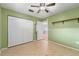A cozy bedroom with a ceiling fan, closet, and a view of an adjacent room through an open door at 5607 Huber Dr, Orlando, FL 32818