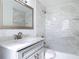 Updated bathroom featuring marble tile, modern vanity, and a shower-tub combination at 930 Lewis Dr, Daytona Beach, FL 32117