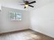 Bright bedroom features wood-look floors, base molding, ceiling fan, and a window at 930 Lewis Dr, Daytona Beach, FL 32117