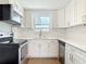 Bright kitchen featuring white cabinets, stainless appliances, quartz countertops, and hardwood floors at 930 Lewis Dr, Daytona Beach, FL 32117