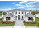 Two-story home with gray roof and white exterior, showcasing a landscaped front yard at 9847 Laurel Berry Dr, Orlando, FL 32827