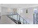 Modern glass and metal staircase with gray tile flooring at 9847 Laurel Berry Dr, Orlando, FL 32827