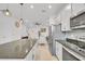 Modern kitchen boasts white cabinets, granite counters, and stainless steel appliances at 1153 Seaside Mist Trl, Kissimmee, FL 34747