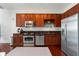 Kitchen with stainless steel appliances, brown cabinets, granite countertops, and hardwood floors at 150 E Robinson St # 1011, Orlando, FL 32801