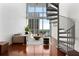 Spacious living room boasts large windows with a view, spiral staircase, and hardwood floors at 150 E Robinson St # 1011, Orlando, FL 32801
