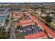 Aerial view of a townhome community featuring mature trees, ample parking, and terracotta roofs at 1606 Sandy Point Sq # 53, Orlando, FL 32807