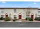 Charming townhome exterior featuring red-trimmed entryways, well-kept landscaping, and a terracotta-tiled roof at 1606 Sandy Point Sq # 53, Orlando, FL 32807